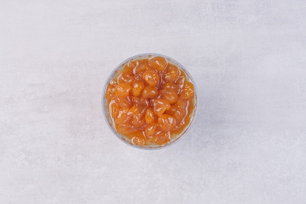 A glass plate of sweet jam on white surface 