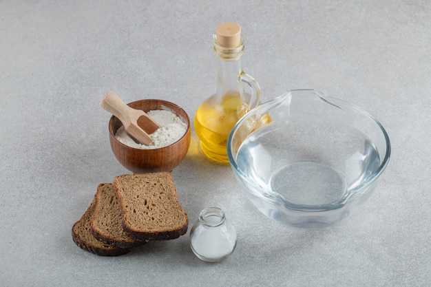 Стеклянная тарелка с водой с кусочками хлеба и маслом.