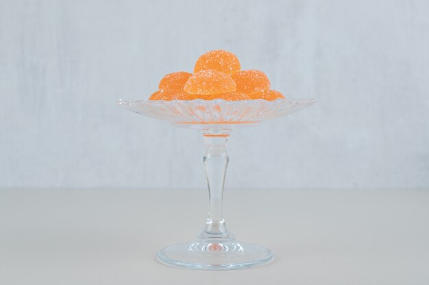 A glass plate with orange sugar marmalade .