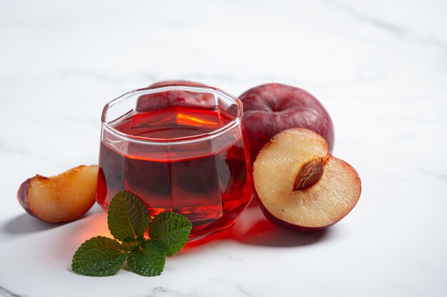 glass of plum put on white marble floor