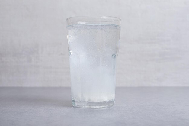 A glass of pure cold water on gray background. 