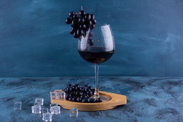 大理石のテーブルに黒ブドウと赤ワインのグラス。