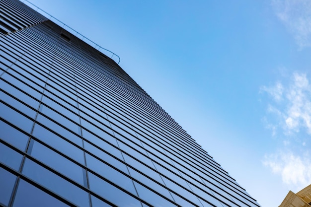 Glass skyscraper against blue sky view from bottom