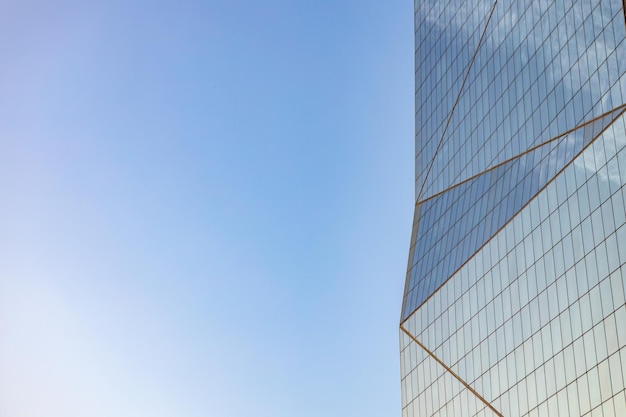 Free photo glass skyscraper against blue sky view from bottom