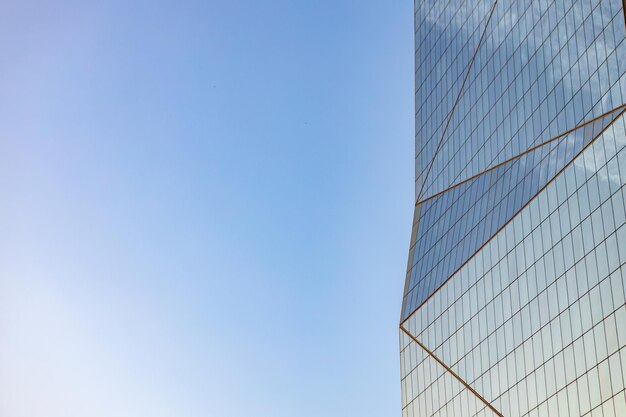 Glass skyscraper against blue sky view from bottom