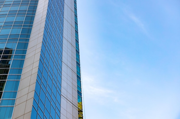 Glass skyscraper against blue sky view from bottom