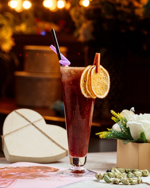 A glass of smoothie garnished with dried orange slices