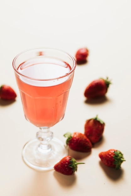 Glass of strawberry juice on plain background