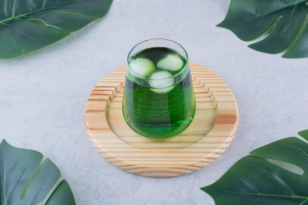 Glass of tarragon juice with ice on wooden plate. High quality photo