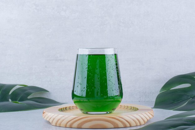 Glass of tarragon juice on wooden plate. High quality photo