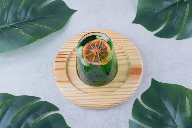 Free photo glass of tarragon juice on wooden plate. high quality photo