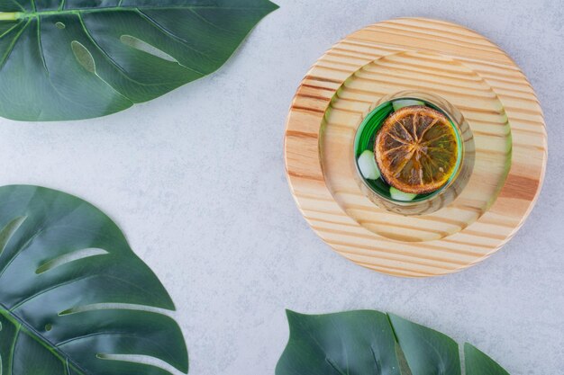 Glass of tarragon juice on wooden plate. High quality photo