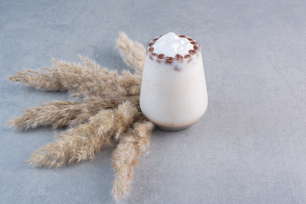 Glass of tasty iced coffee with milk on stone table.