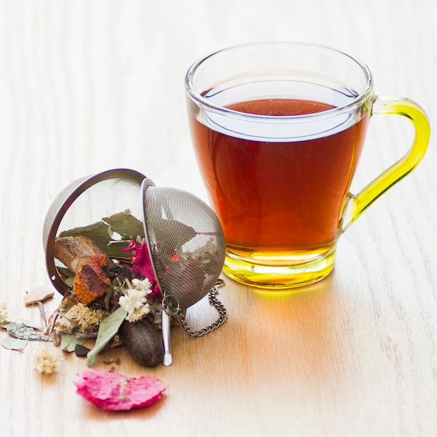 Bicchiere di tè con foglie secche