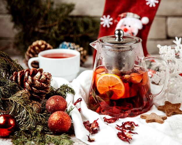 A glass teapot filled with strawberry raspberry tea with lemon and mint