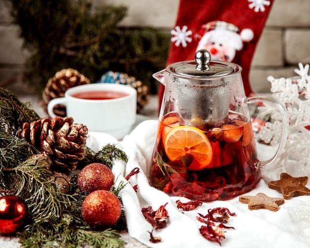 A glass teapot filled with strawberry raspberry tea with lemon and mint