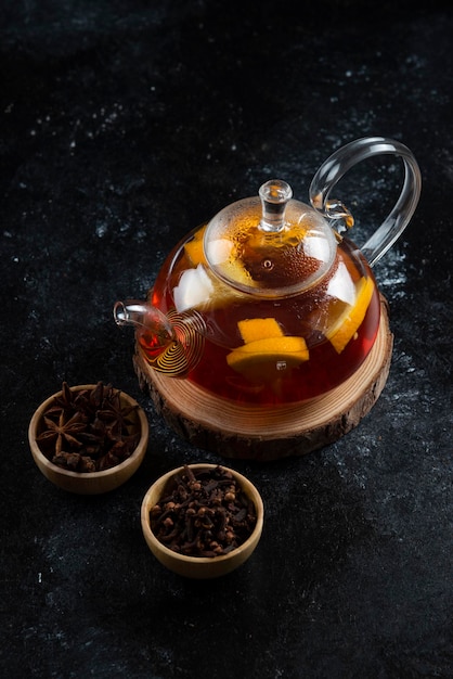 Стеклянный чайник с горячим чаем и сушеной гвоздикой.