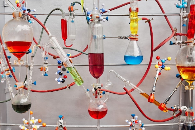 Стеклянные пробирки с разноцветной вязкой жидкостью, изолированной на серой поверхности в химической лаборатории