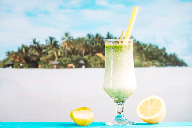 Glass of tropical sour smoothie and sliced citrus 