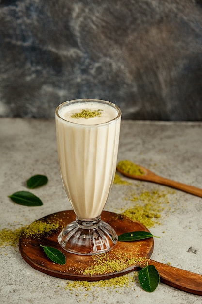 A glass of vanilla milkshake with pistachio sprinkles