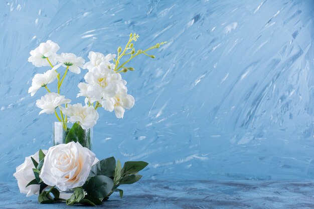青に美しい新鮮な白いバラの花が付いたガラスの花瓶。