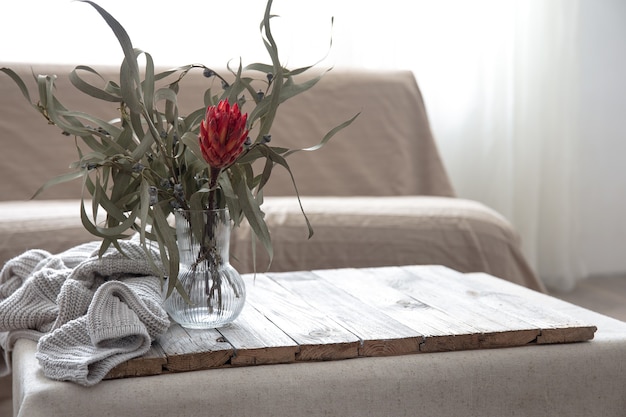 Glass vase with protea flower in the interior of the room, copy space.