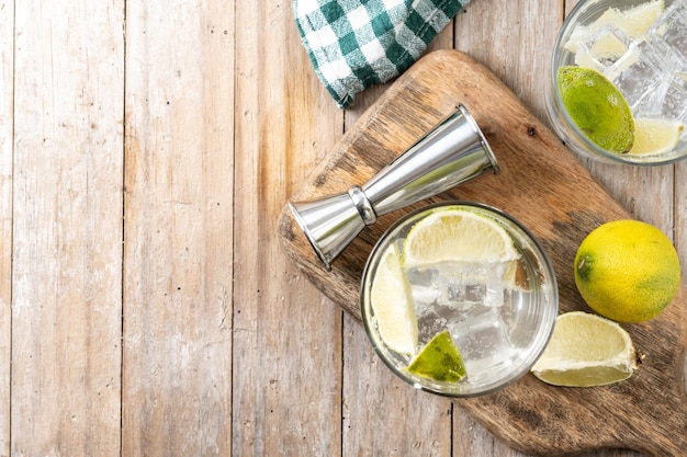 Free photo glass of vodka tonic cocktail on wooden table