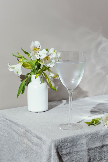 Glass of water and flowers on table