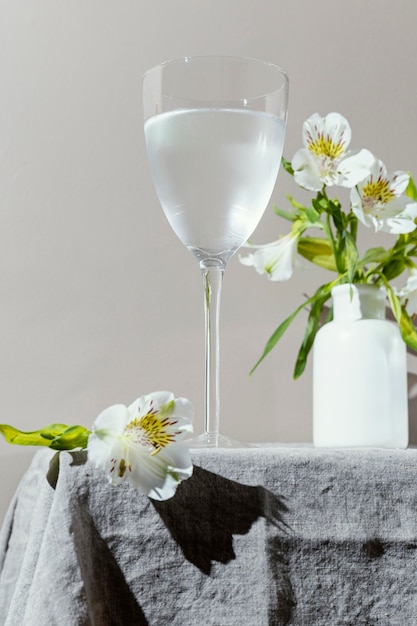 Glass of water and flowers on table