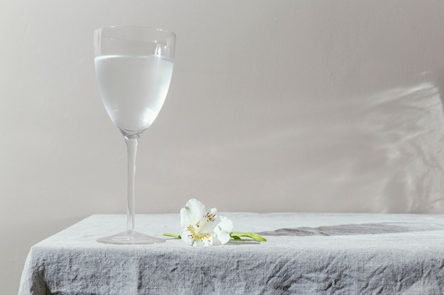 Glass of water and flowers on table