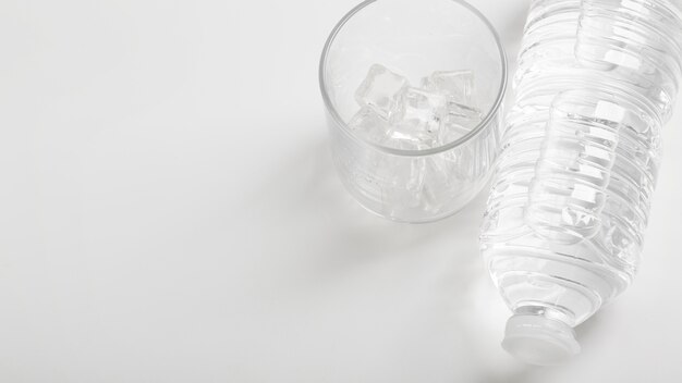 Glass of water and plastic bottle white copy space