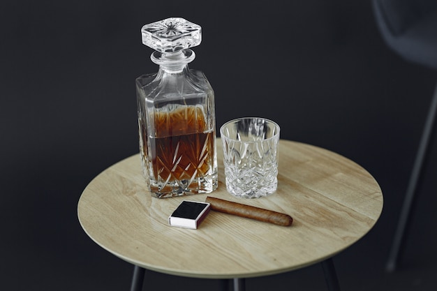 テーブルの上の葉巻とウイスキーのガラス。アルコールと葉巻の写真をクローズアップ。