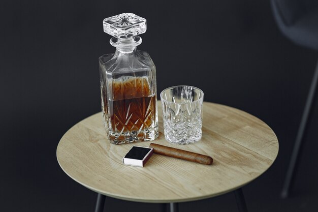 テーブルの上の葉巻とウイスキーのガラス。アルコールと葉巻の写真をクローズアップ。