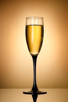 Glass of white wine over gold background