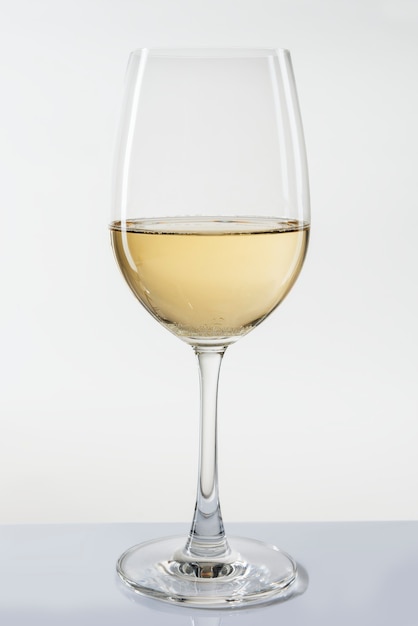 Glass of white wine on white background