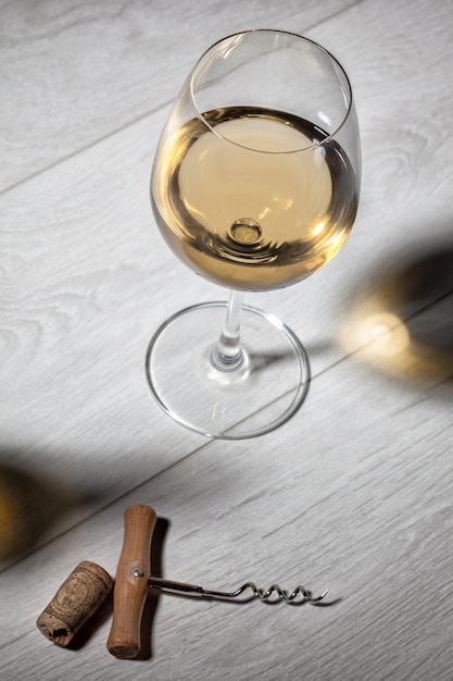 Glass of white wine on wooden table Top view