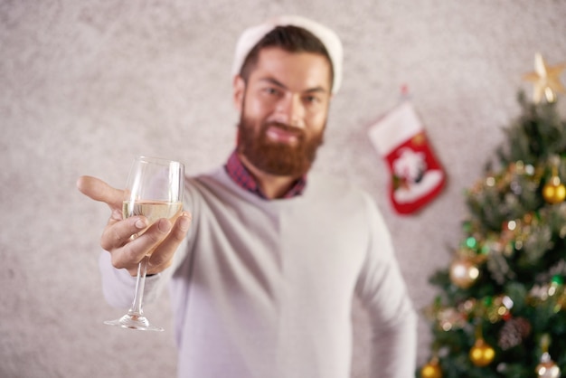 Glass of wine or champagne in hands of smiling Christmas party guest