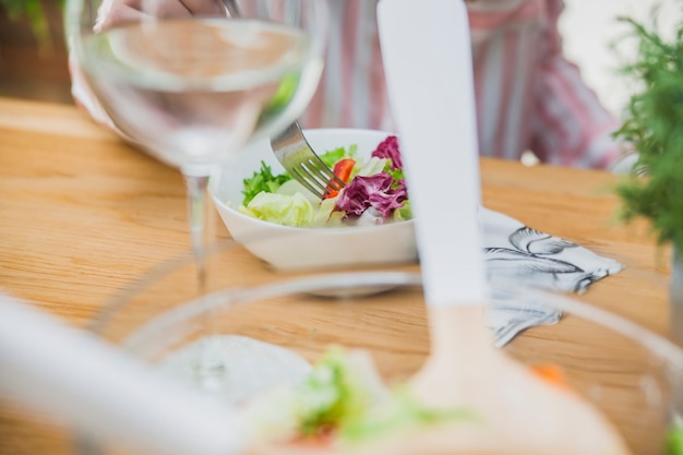 Glass of wine and salad on table