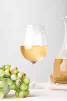 Foto gratuita bicchiere di vino con il primo piano verde dell'uva