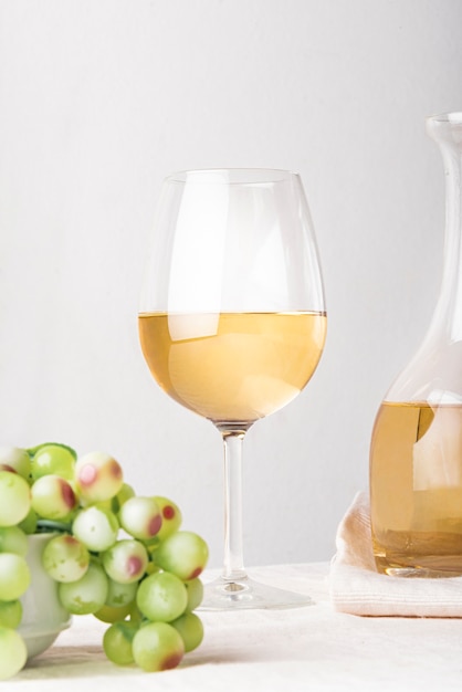 Glass of wine with green grapes close-up