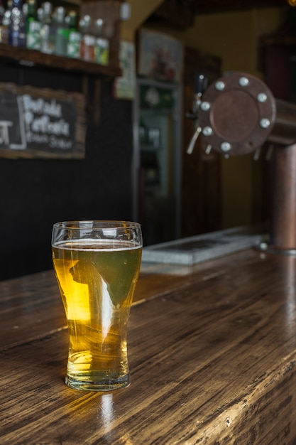 Glass with beer at bar on table