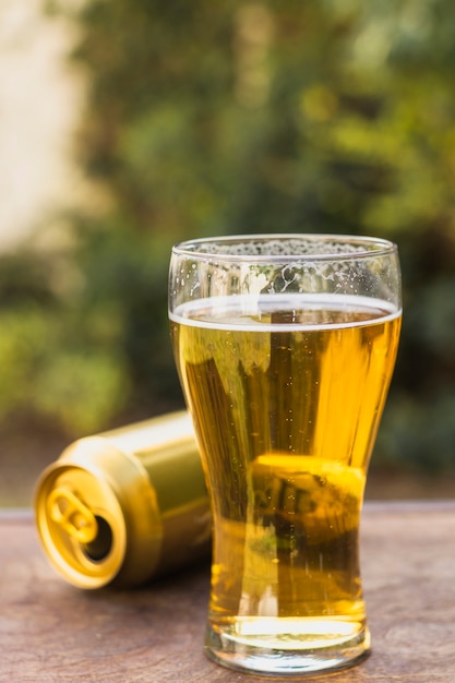 Glass with beer beside beer can