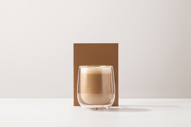 Glass with delicious coffee and white background