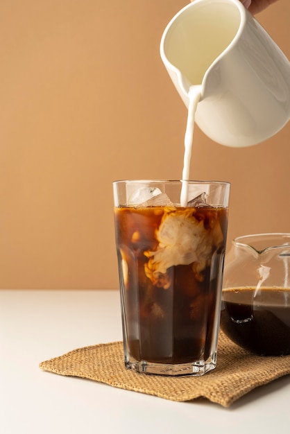 Glass with iced coffee on table