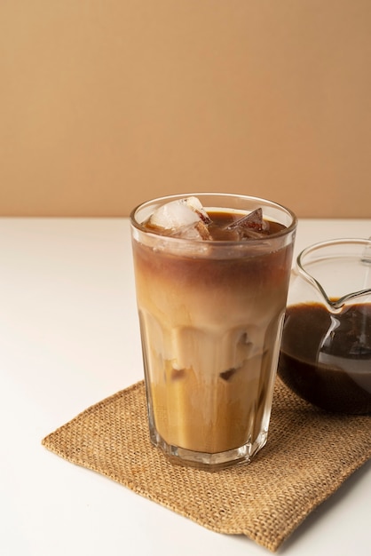 Glass with iced coffee on table