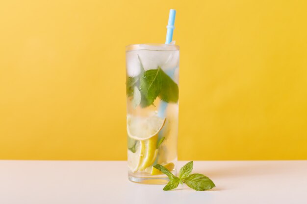 Glass with iced tea with lemon slices, mint and ice cubes