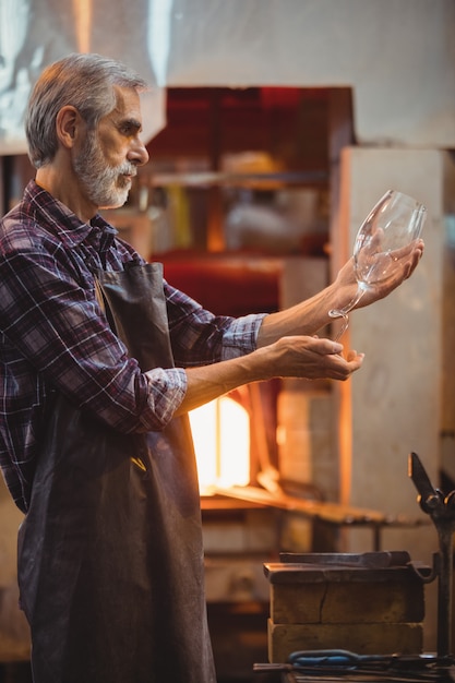 Glassblower examining glassware