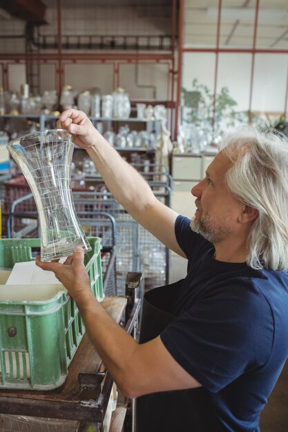 Glassblower examining glassware