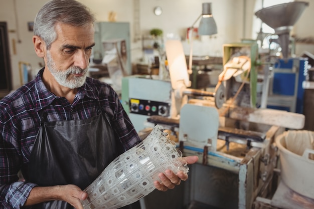 Free photo glassblower examining glassware