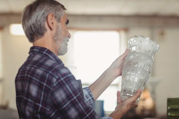 Free photo glassblower examining glassware